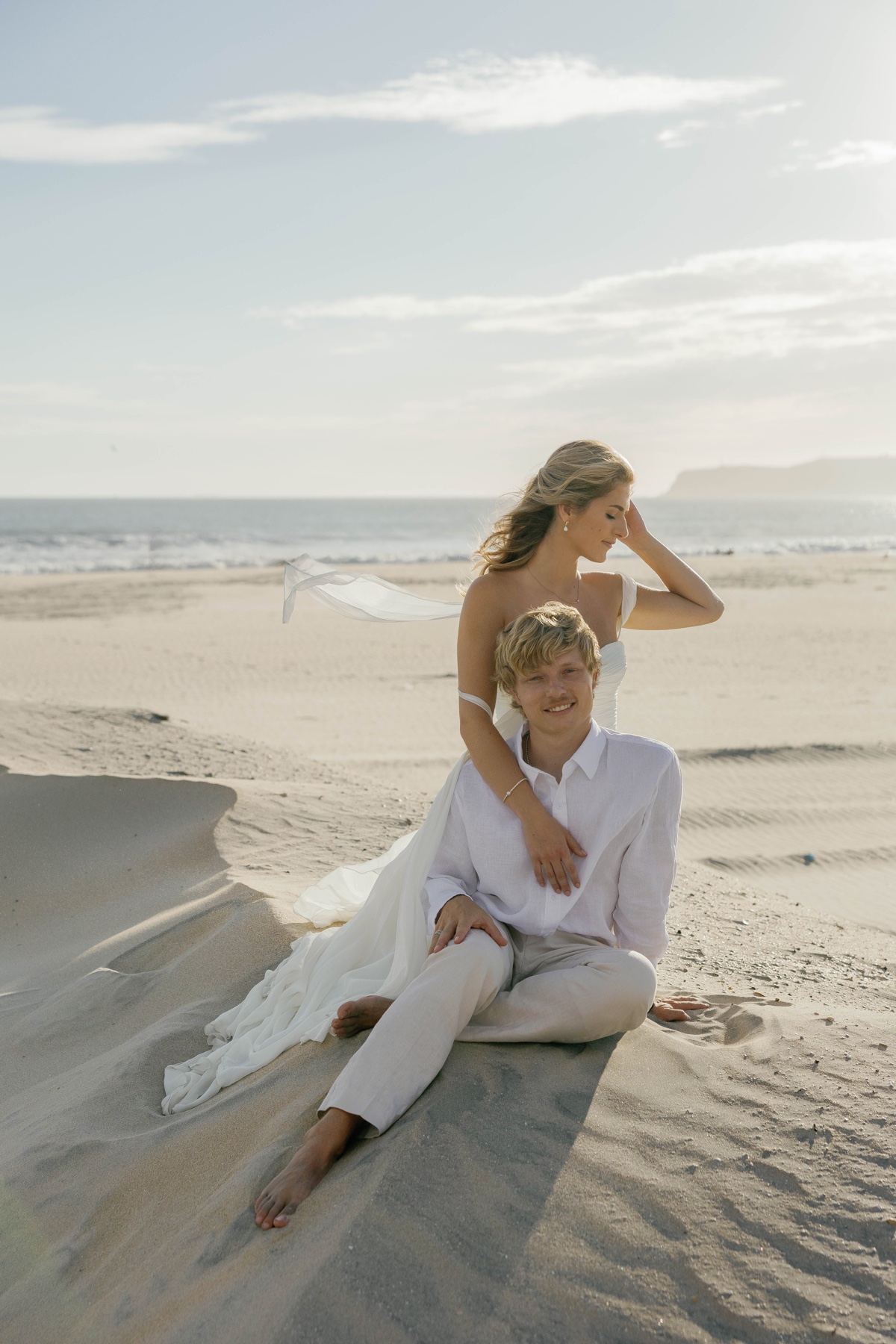 Jade and Patrick sitting together on the beach