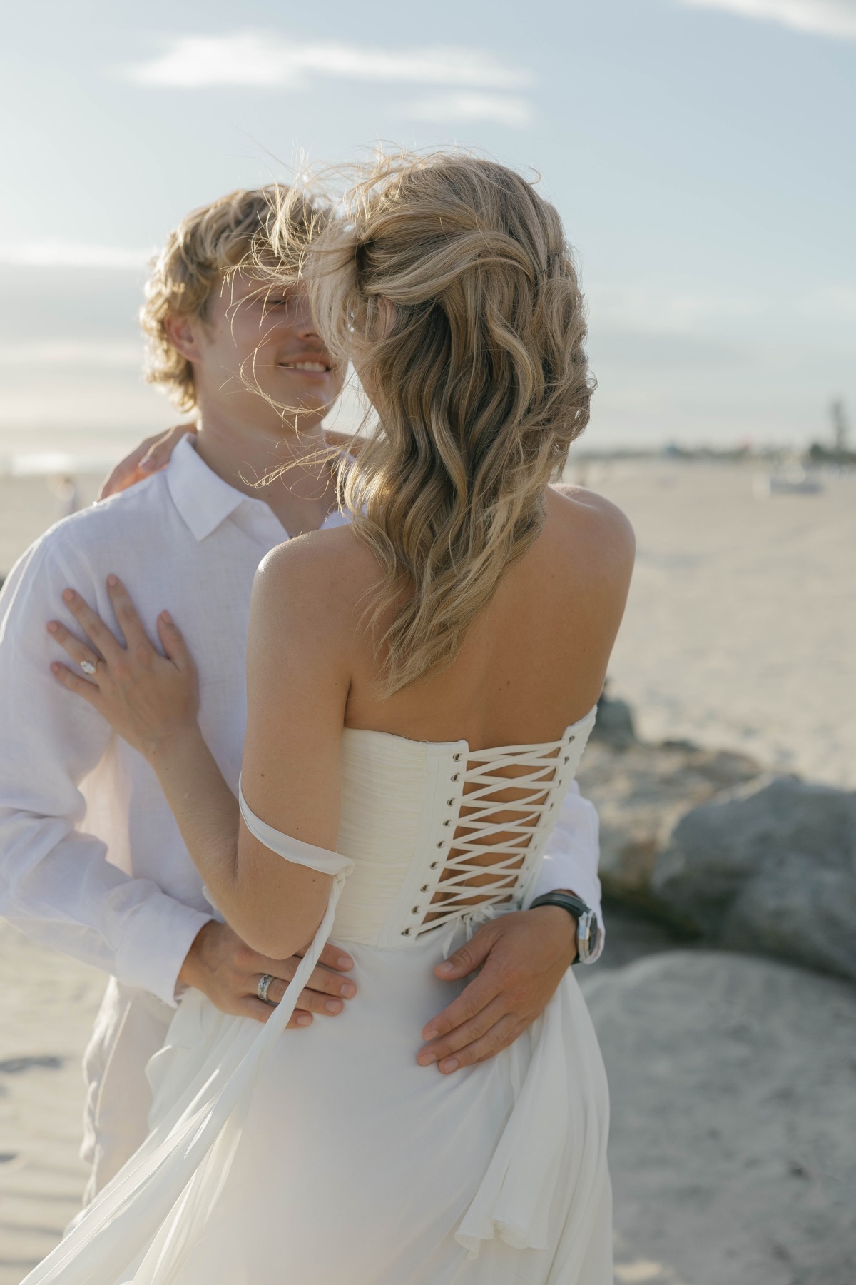Jade and Patrick embracing on the beach