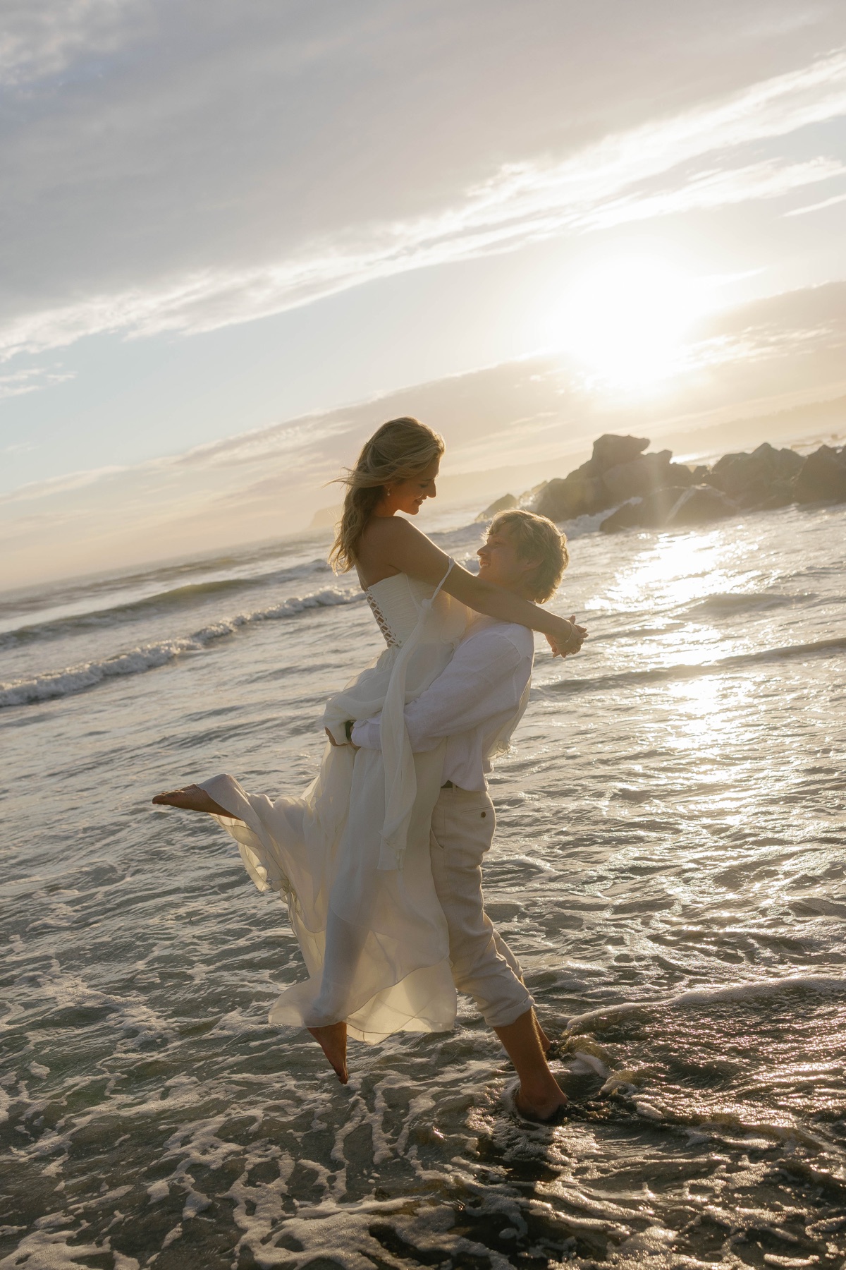Jade and Patrick dancing in the ocean at sunset